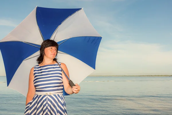 Брюнетка жінка з пляжною парасолькою — стокове фото