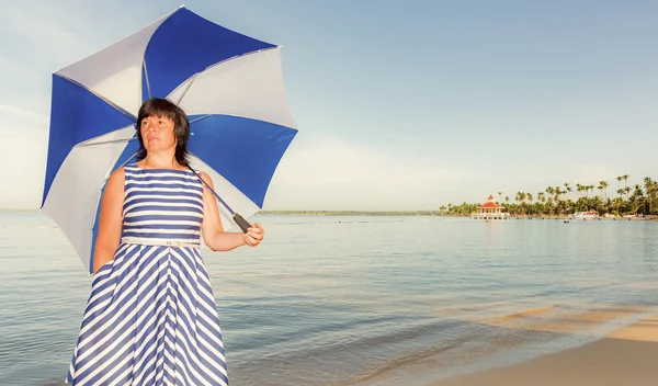 Брюнетка с пляжным зонтиком — стоковое фото