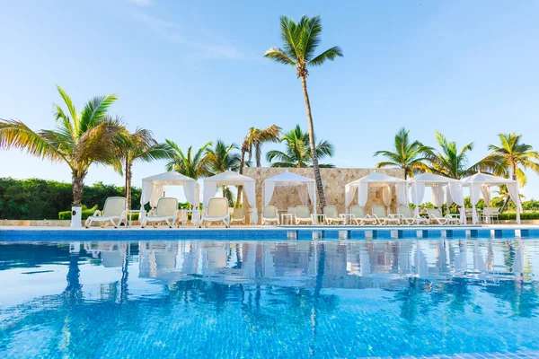 Une piscine avec chaises longues — Photo