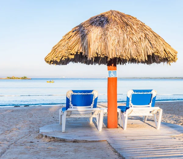 Two deck chairs under an umbrella — Stock Photo, Image