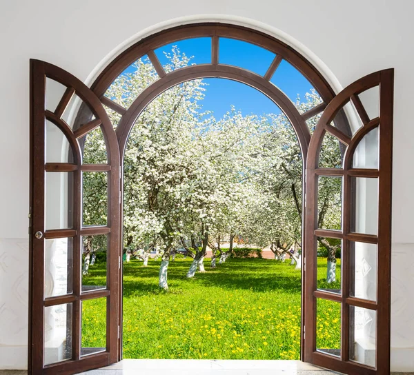 Porta aperta arco fioritura giardino in primavera — Foto Stock