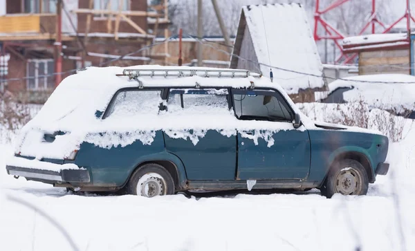 old car covered with snow