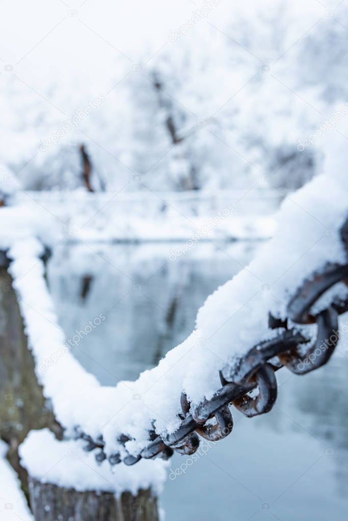 old rusty iron chain on a frost covered with snow