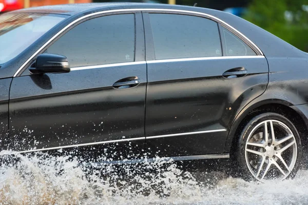 車の雨の水たまりが水を撒く — ストック写真