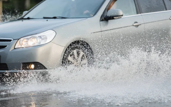 Coche lluvia charco salpicaduras de agua —  Fotos de Stock