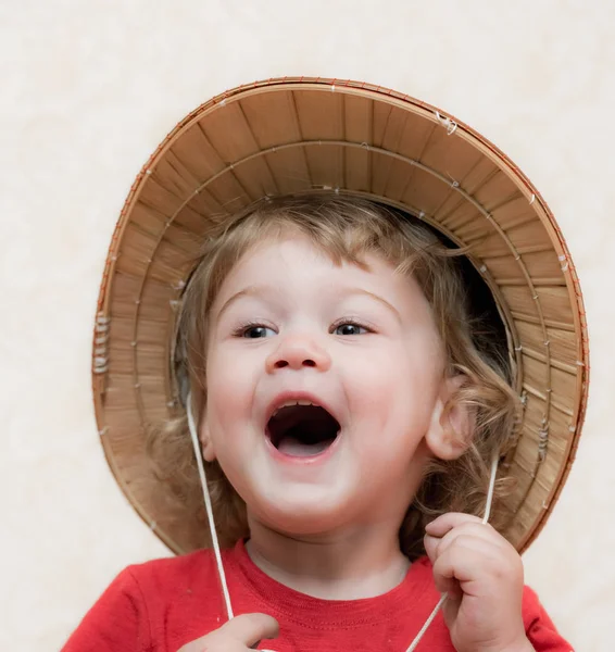 Blond curly-haired child straw hat — Stock Photo, Image