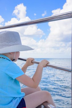 bir yatta şapkalı bir çocuk