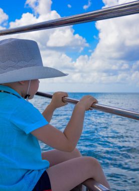 bir yatta şapkalı bir çocuk