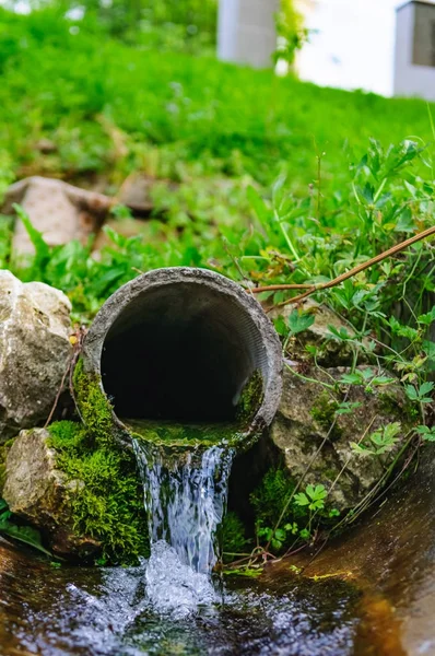 Pipe from the ground flowing ecological clean water — Stock Photo, Image