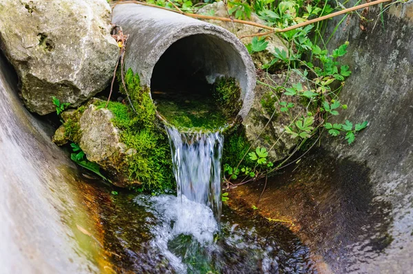 生態学的なきれいな水の流れる地上からパイプ — ストック写真