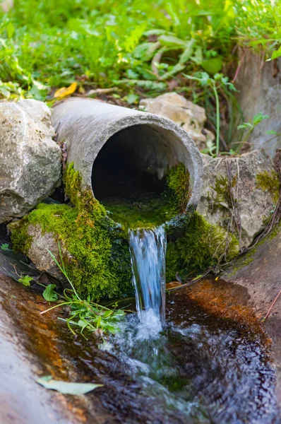 Pipe from the ground flowing ecological clean water — Stock Photo, Image