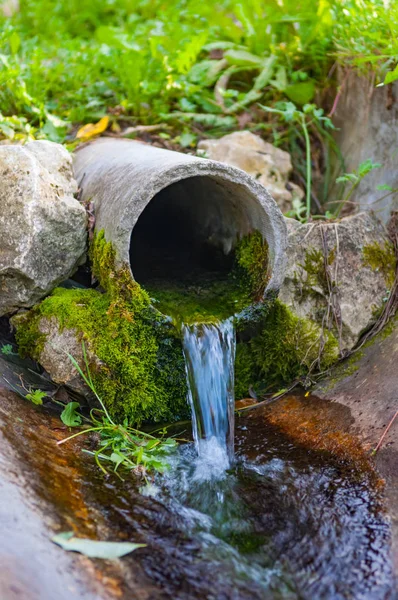 Tubo da terra che scorre acqua pulita ecologica — Foto Stock