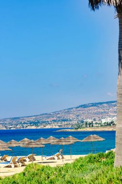 Grup şezlonglar kumsal deniz tropikal güneşli bir günde bir şemsiye altında