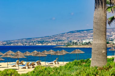 Grup şezlonglar kumsal deniz tropikal güneşli bir günde bir şemsiye altında