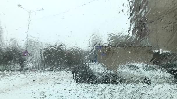雨で湿った雪が冬の悪天候をゆっくりと滴下ガラスに落ちる — ストック動画