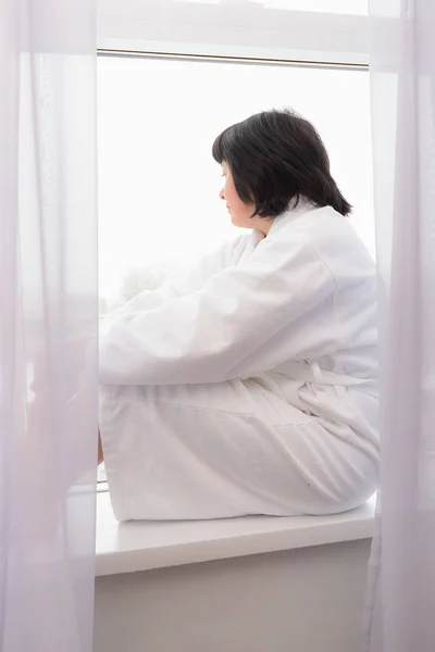 Middle-aged woman by the window — Stock Photo, Image