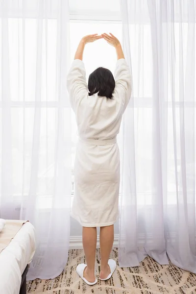 Uma mulher está a arrastar-se de manhã pela janela — Fotografia de Stock