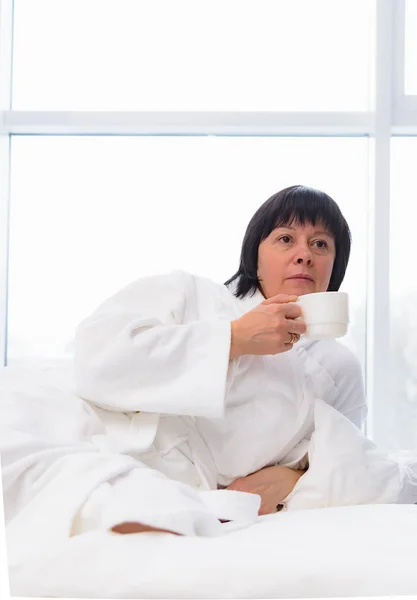 Femme le matin au lit avec une tasse de café — Photo