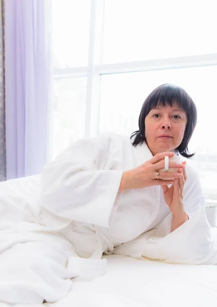 Femme le matin au lit avec une tasse de café — Photo