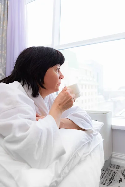 Femme le matin au lit avec une tasse de café — Photo