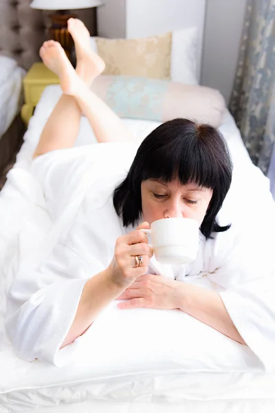 Femme le matin au lit avec une tasse de café — Photo