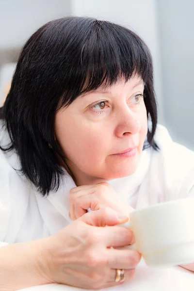 Žena ráno s šálkem kávy v posteli — Stock fotografie