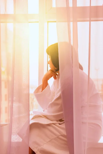 Femme par la fenêtre lumière du soleil — Photo