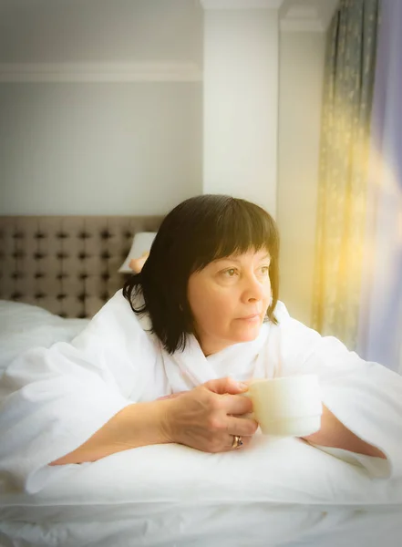 Femme le matin au lit avec une tasse de café — Photo