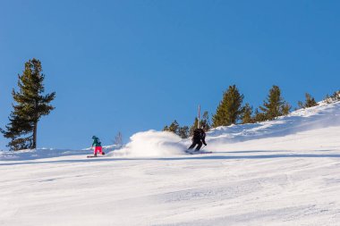 Bulgaristan. Bansko. 10 Şubat 2020. Büyük kar tarlasında kayak yapan kayakçı. Kar tozu sıçratıyor.