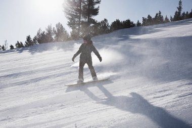 Bulgaristan. Bansko. 10 Şubat 2020. Büyük kar tarlasında kayak yapan kayakçı. Kar tozu sıçratıyor.