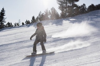 Bulgaristan. Bansko. 10 Şubat 2020. Büyük kar tarlasında kayak yapan kayakçı. Kar tozu sıçratıyor.