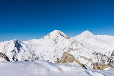 Dağın tepesinde karşı bir bulutlu gökyüzü kışın karda