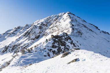 Dağın tepesinde karşı bir bulutlu gökyüzü kışın karda