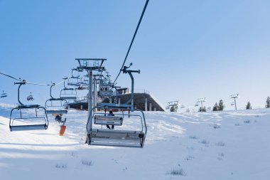 Bulgaristan. Bansko. 10 Şubat 2020 'de Bansko' da bir tatil köyünde. Karlı kayak pistleri ve sandalye kaldırma istasyonları. Güneşli bir günde mavi gökyüzünün altında