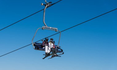 Bulgaristan. Bansko. 10 Şubat 2020 'de Bansko' da bir tatil köyünde. Karlı kayak pistleri ve sandalye kaldırma istasyonları. Güneşli bir günde mavi gökyüzünün altında