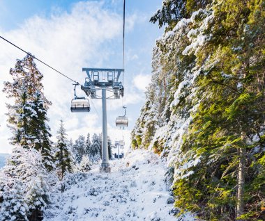 Bulgaristan. Bansko. 10 Şubat 2020 'de Bansko' da bir tatil köyünde. Karlı kayak pistleri ve sandalye kaldırma istasyonları. Güneşli bir günde mavi gökyüzünün altında