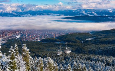 Bulgaristan. Bansko. 10 Şubat 2020 'de Bansko' da bir tatil köyünde. Karlı kayak pistleri ve sandalye kaldırma istasyonları. Güneşli bir günde mavi gökyüzünün altında