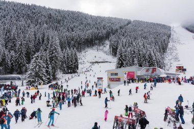 Bansko, Bulgaria - February 14, 2020: Winter ski resort Bansko, ski slope, people skiing and mountains view.
