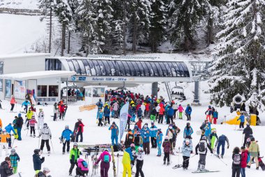 Bansko, Bulgaria - February 14, 2020: Winter ski resort Bansko, ski slope, people skiing and mountains view.