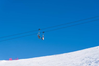 Bulgaristan. Bansko. 10 Şubat 2020 'de Bansko' da bir tatil köyünde. Karlı kayak pistleri ve sandalye kaldırma istasyonları. Güneşli bir günde mavi gökyüzünün altında