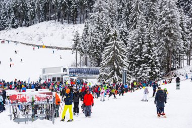 Bansko, Bulgaria - February 14, 2020: Winter ski resort Bansko, ski slope, people skiing and mountains view.