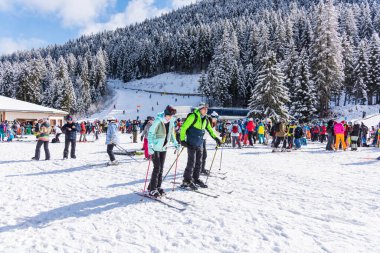 Bansko, Bulgaria - February 14, 2020: Winter ski resort Bansko, ski slope, people skiing and mountains view.