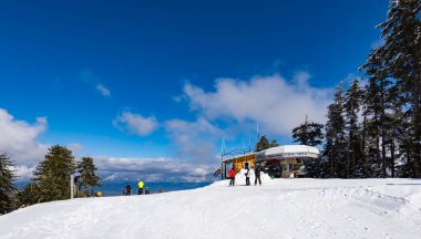 Bansko, Bulgaria - February 14, 2020: Winter ski resort Bansko, ski slope, people skiing and mountains view.