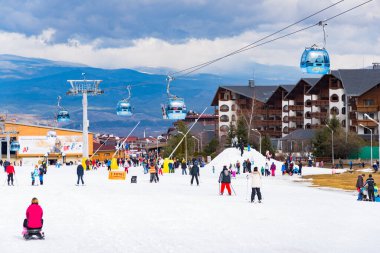 Bansko, Bulgaria - February 14, 2020: Winter ski resort Bansko, ski slope, people skiing and mountains view.