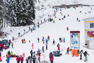 Bansko, Bulgaria - February 14, 2020: Winter ski resort Bansko, ski slope, people skiing and mountains view.