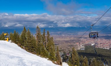 Bulgaristan. Bansko. 10 Şubat 2020 'de Bansko' da bir tatil köyünde. Karlı kayak pistleri ve sandalye kaldırma istasyonları. Güneşli bir günde mavi gökyüzünün altında