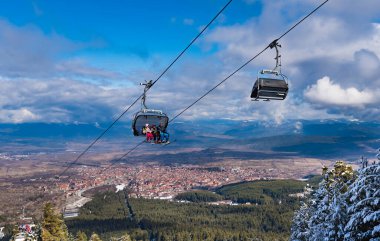 Bulgaristan. Bansko. 10 Şubat 2020 'de Bansko' da bir tatil köyünde. Karlı kayak pistleri ve sandalye kaldırma istasyonları. Güneşli bir günde mavi gökyüzünün altında