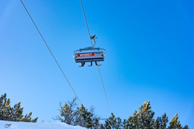 Bulgaristan. Bansko. 10 Şubat 2020 'de Bansko' da bir tatil köyünde. Karlı kayak pistleri ve sandalye kaldırma istasyonları. Güneşli bir günde mavi gökyüzünün altında