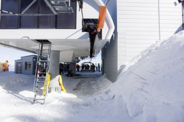 Bulgaristan. Bansko. 10 Şubat 2020 'de Bansko' da bir tatil köyünde. Karlı kayak pistleri ve sandalye kaldırma istasyonları. Güneşli bir günde mavi gökyüzünün altında