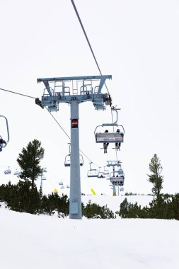 Bulgaristan. Bansko. 10 Şubat 2020 'de Bansko' da bir tatil köyünde. Karlı kayak pistleri ve sandalye kaldırma istasyonları. Güneşli bir günde mavi gökyüzünün altında